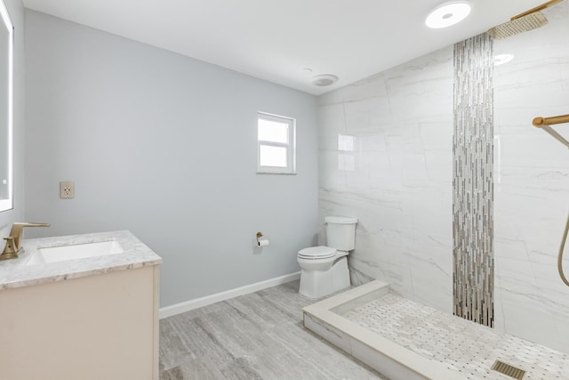 bathroom with toilet, vanity, tile walls, wood-type flooring, and a tile shower