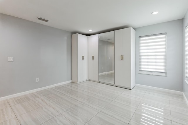 unfurnished bedroom with light tile patterned floors and a closet