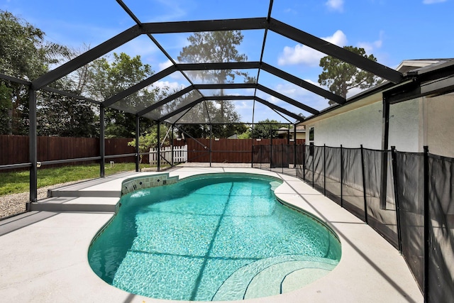 view of pool featuring glass enclosure and a patio area