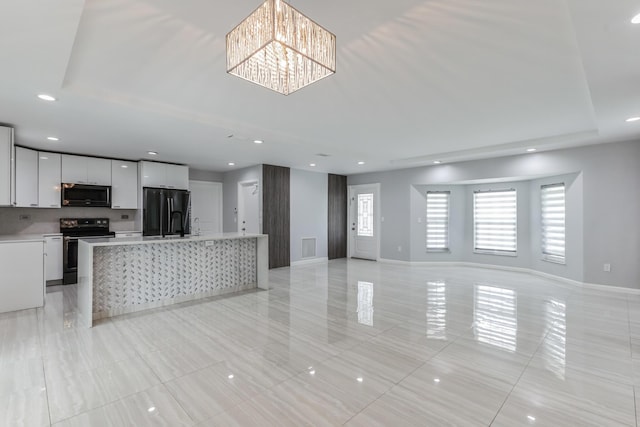 kitchen featuring white cabinets, a kitchen island, black refrigerator with ice dispenser, a notable chandelier, and stainless steel electric range