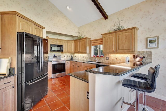 kitchen with wallpapered walls, a peninsula, dark tile patterned flooring, a sink, and black appliances