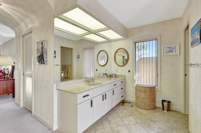 bathroom with vanity, tile patterned floors, and baseboards