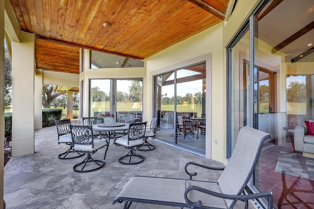 sunroom / solarium featuring lofted ceiling and wood ceiling