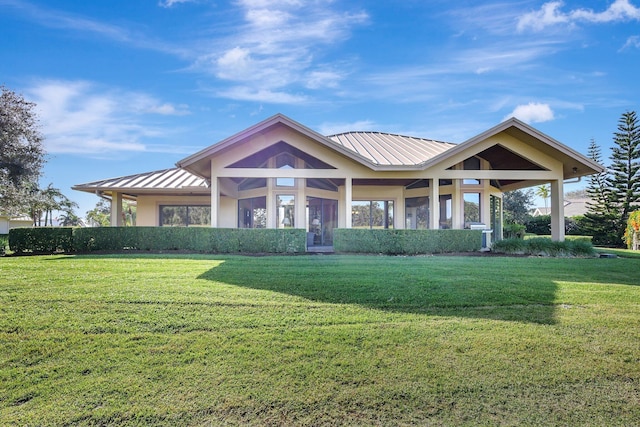 view of front of property with metal roof, a front lawn, and a standing seam roof