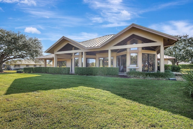 view of front of house with metal roof, a front lawn, and a standing seam roof