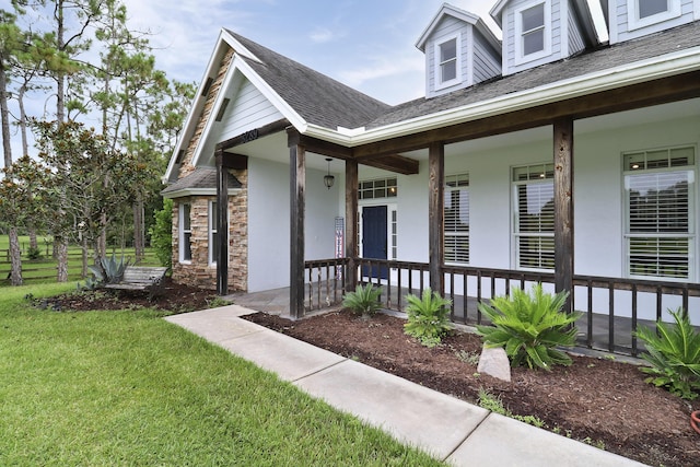 entrance to property featuring a lawn and covered porch