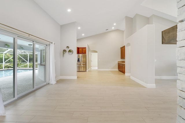 hallway featuring light hardwood / wood-style floors and high vaulted ceiling