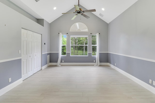 interior space with ceiling fan, a closet, high vaulted ceiling, and light hardwood / wood-style flooring