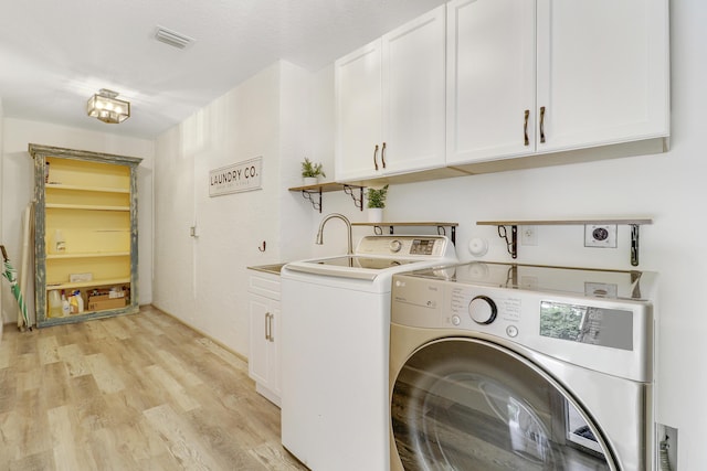 clothes washing area featuring cabinets, separate washer and dryer, light hardwood / wood-style flooring, and sink