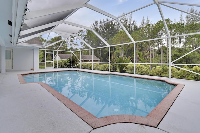 view of pool with a patio area and glass enclosure