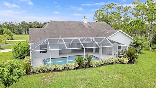 back of house with a yard, glass enclosure, and a patio area