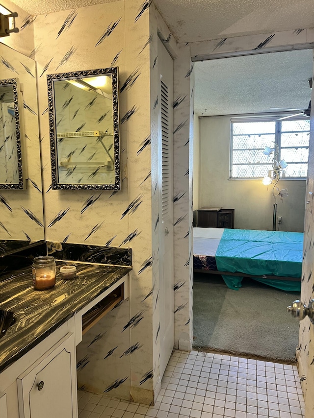 bathroom with tile patterned floors, vanity, and a textured ceiling