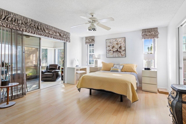 bedroom featuring a textured ceiling, light wood-type flooring, access to outside, and ceiling fan