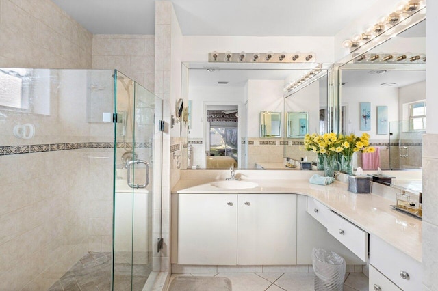 bathroom featuring tile patterned flooring, vanity, and a shower with shower door