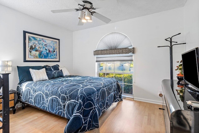 bedroom with wood-type flooring, a textured ceiling, and ceiling fan