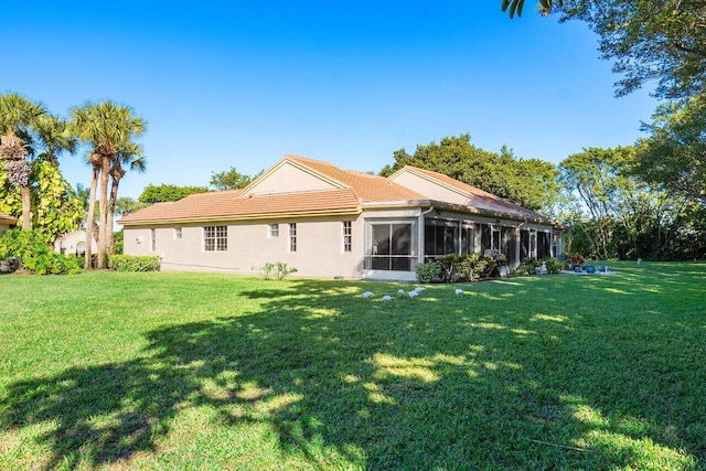 rear view of house with a sunroom and a yard