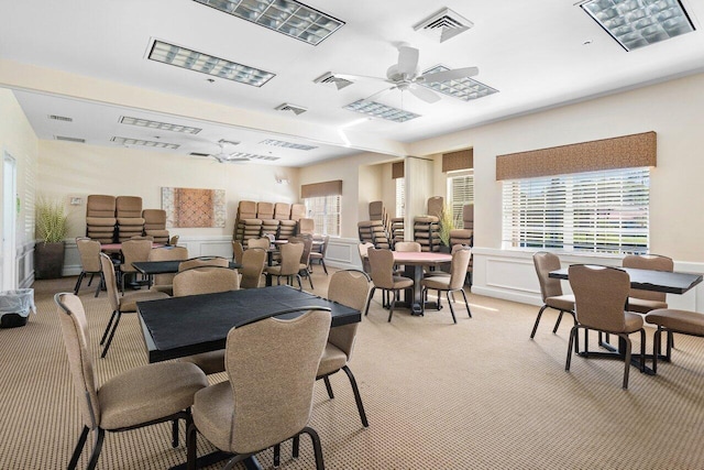 carpeted dining room featuring ceiling fan