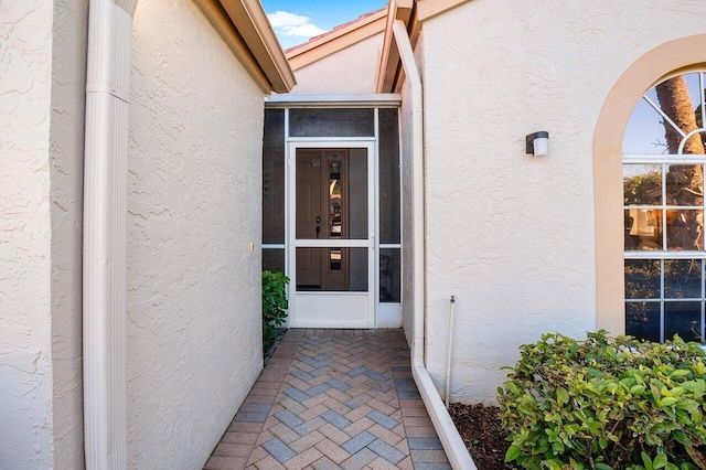 view of exterior entry featuring stucco siding