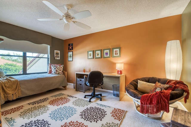 carpeted bedroom featuring ceiling fan and a textured ceiling