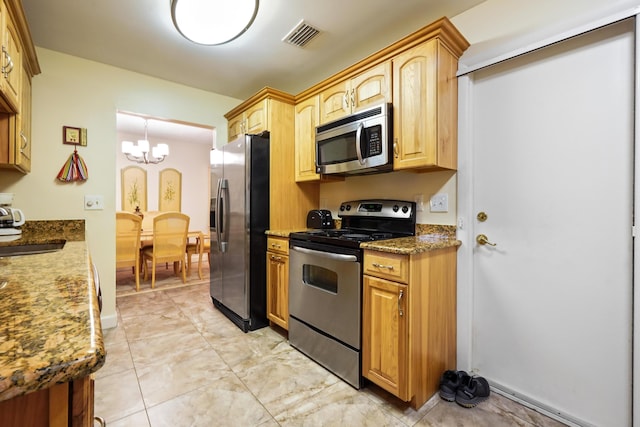 kitchen with visible vents, a sink, stainless steel appliances, stone counters, and a chandelier