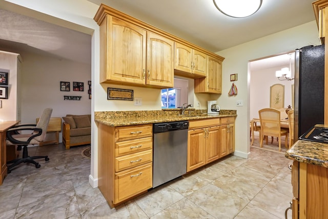 kitchen with stone counters, stainless steel appliances, baseboards, and a sink