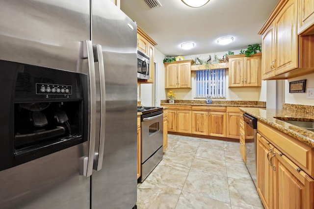 kitchen featuring light stone counters, visible vents, appliances with stainless steel finishes, and light brown cabinetry