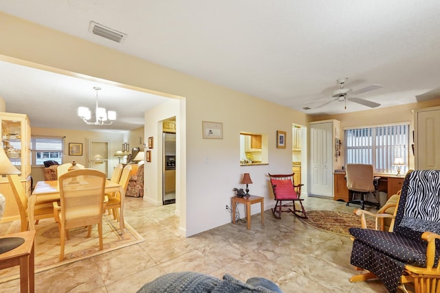 living area with visible vents, baseboards, a healthy amount of sunlight, and ceiling fan with notable chandelier