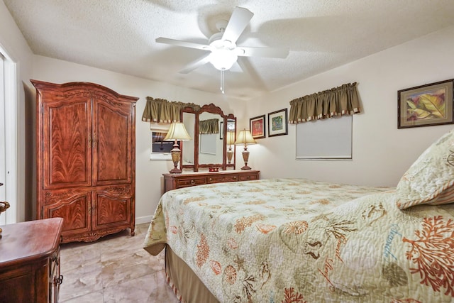 bedroom with ceiling fan and a textured ceiling