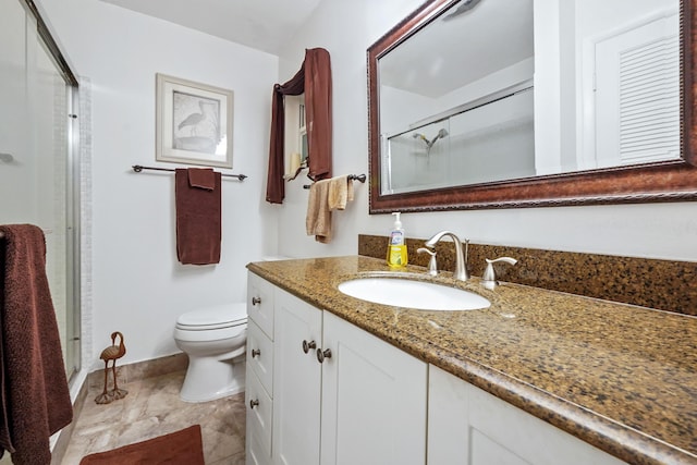 bathroom featuring vanity, a shower stall, toilet, and baseboards