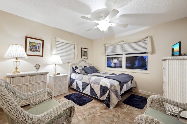 bedroom featuring a textured ceiling, baseboards, and a ceiling fan