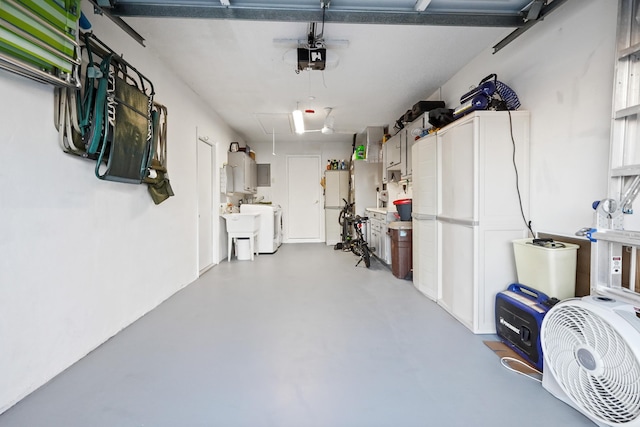 garage with washer / clothes dryer, a garage door opener, water heater, and freestanding refrigerator