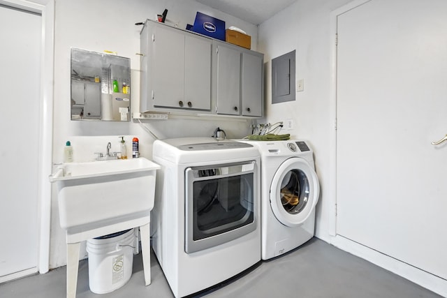 laundry room with electric panel, cabinet space, and washer and clothes dryer