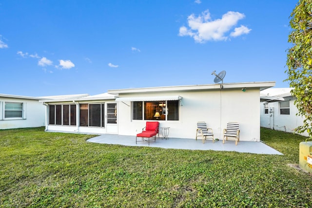 back of house featuring a patio, a lawn, a sunroom, and stucco siding