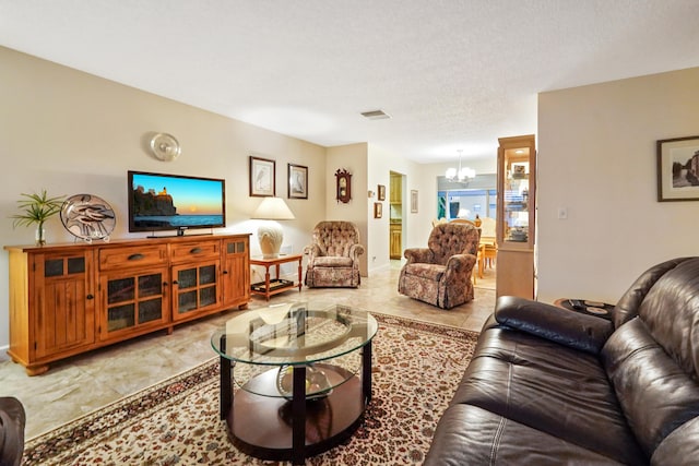 living room with an inviting chandelier, visible vents, and a textured ceiling