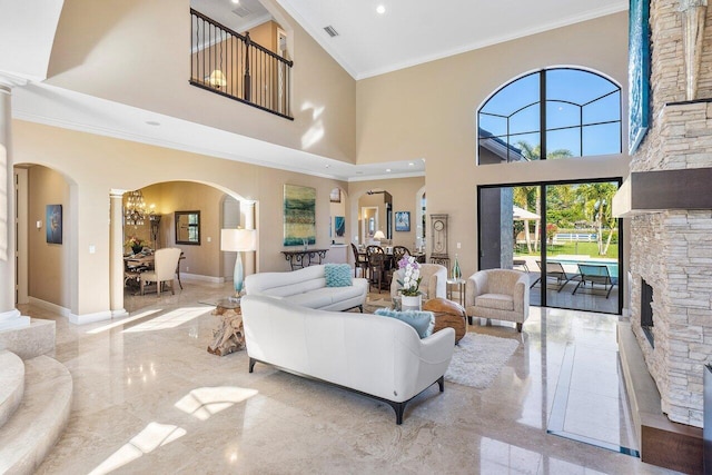 living room with a fireplace, a high ceiling, a chandelier, and crown molding