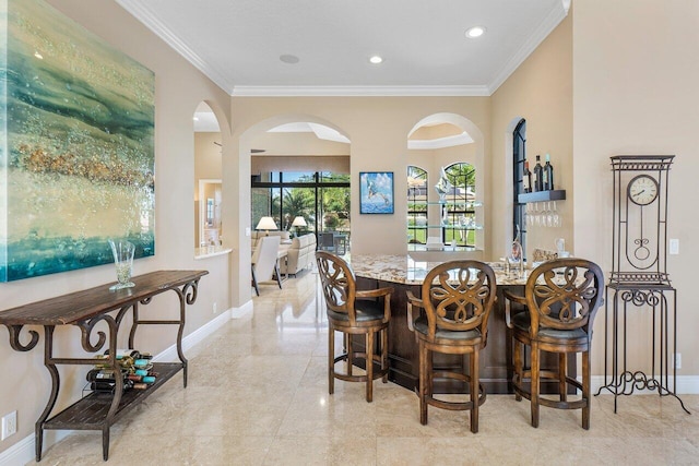 dining room with bar and crown molding