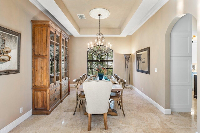 dining area featuring a tray ceiling and an inviting chandelier