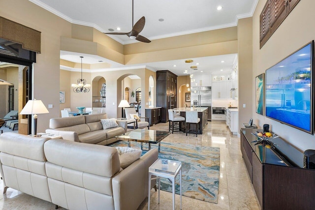 living room featuring ceiling fan with notable chandelier, a towering ceiling, and crown molding