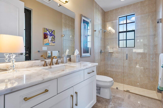 bathroom with vanity, toilet, and a shower with door