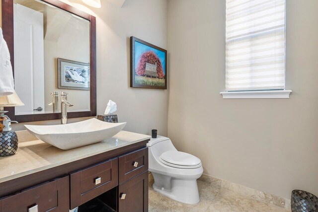 bathroom with tile patterned flooring, vanity, and toilet