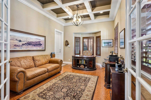 living room featuring ornamental molding, coffered ceiling, beam ceiling, hardwood / wood-style flooring, and a notable chandelier