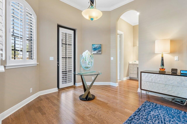 foyer featuring wood-type flooring and crown molding