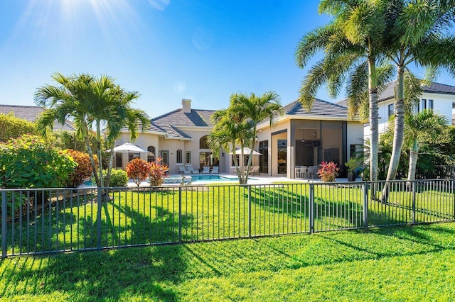 back of property featuring a fenced in pool and a yard