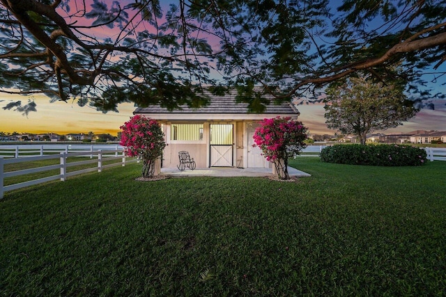 outdoor structure at dusk featuring a lawn