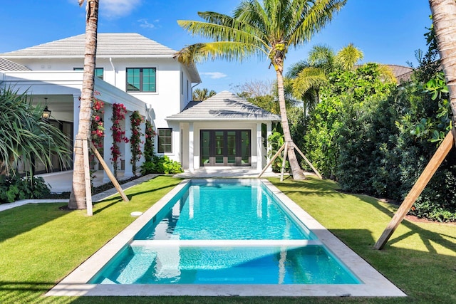 view of swimming pool featuring a yard, french doors, and a pool with connected hot tub