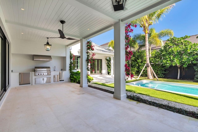 view of patio / terrace featuring sink, grilling area, ceiling fan, a fenced in pool, and exterior kitchen