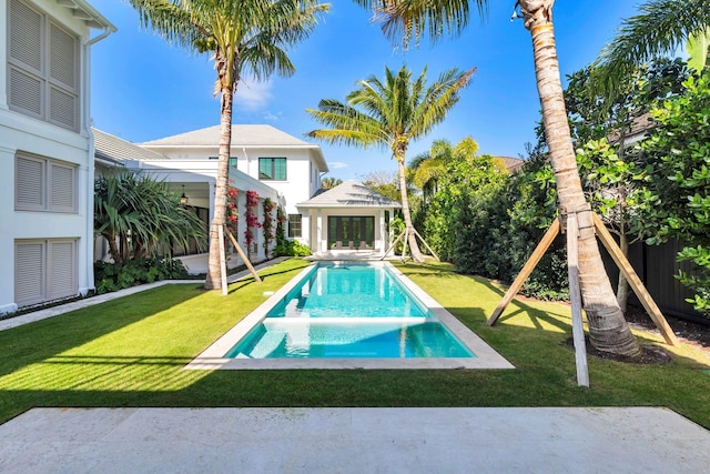 view of swimming pool with a lawn and an outdoor structure