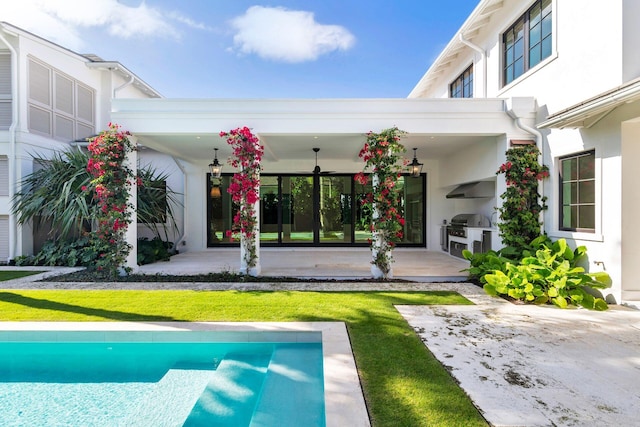 exterior space featuring a lawn, exterior kitchen, ceiling fan, and a patio