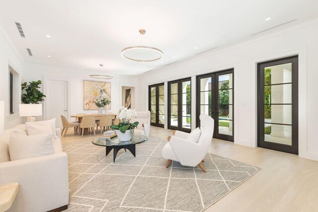 empty room featuring ornamental molding, light hardwood / wood-style flooring, and french doors