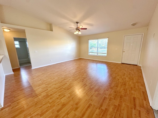 empty room featuring vaulted ceiling, ceiling fan, and light wood-type flooring